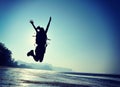 Young woman hiker jumping on sunrise beach Royalty Free Stock Photo