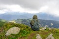 Young woman hiker sit in beautiful mountains on hiking trip. Active tourist resting outdoors in nature. Backpacker camping