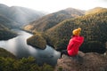 Young woman hiker standing on mountain ridge reaching the summit at Lucaci Stone