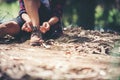 Young woman hiker stops to tie her shoe on a summer hiking trail Royalty Free Stock Photo