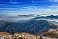 Young woman hiker taking photo with camera on mountains peak.