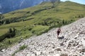 young woman hiker walking along a rough and very steep path alon