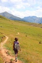 Young woman hiker walks in the high mountain trail in the Italian Alps on the Dolomites mountain range Royalty Free Stock Photo