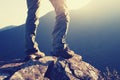 woman hikers standing on cliff`s edge in the sunrise