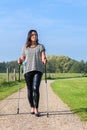 Young woman hikes with Nordic Walking sticks