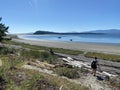 A young woman hiking alone at low tide between Denman Island and JÃ¡ji7em and Kwâulh Marine Park