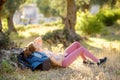 Young woman hiking in countryside. Girl is lying under the tree and having rest and relax. Concepts of adventure, extreme survival Royalty Free Stock Photo