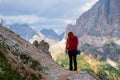 Young woman hiking in the Dolomites mountains, Italy, on Giro delle Cinque Torri, with storm clouds approaching. Guiding, touring