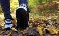 Young woman hiking and going camping in nature. Female legs in sneakers, a woman running in an autumn park among yellow leaves Royalty Free Stock Photo