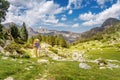 Woman hiking in the mountains with a backpack and trekking poles. Mountain trail route concept Royalty Free Stock Photo