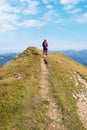 young woman at hiking trail Rofanspitze, back side. blue sky with clouds. vertical shot Royalty Free Stock Photo