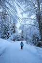 young woman hiking in wintry landscape at snowy road