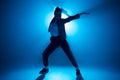 Young woman hip-hop dancer on studio blue light background with flare effects Royalty Free Stock Photo