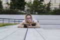 Young woman hipster reading a book lying on the bench in summer Royalty Free Stock Photo