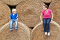 Young woman with his son on the bales Royalty Free Stock Photo