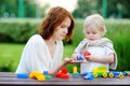 Young woman with his toddler son playing with colorful plastic blocks Royalty Free Stock Photo