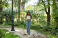 Young woman, Hispanic, beautiful, brunette, with daisy t-shirt and jeans, walking in a park, quiet and lonely. Concept of beauty,