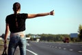 Young woman hitchhiking on the road Royalty Free Stock Photo