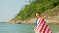 young women hold American flags on the beach and the sea on their summer vacation and they smile and enjoy their vacation Royalty Free Stock Photo