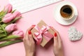 Young woman hold gift on decorated background, top view