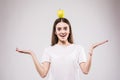 Young woman hold green fresh apple on head, female happy smile think looking up side to empty copy space, isolated on gray backgro