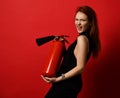 Young woman hold hand fire extinguisher to put out fire screaming on red Royalty Free Stock Photo