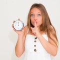 Young woman holding alarm clock and hushing Royalty Free Stock Photo