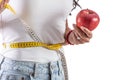 Young woman holding an apple and a measuring tape as a healthy lifestyle concept. Isolated background Royalty Free Stock Photo