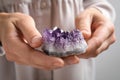 Young woman holding beautiful amethyst gemstone