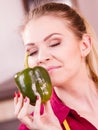 Woman holding bell pepper paprika thinking