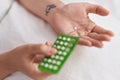 Young woman holding birth control pills at bedroom Royalty Free Stock Photo