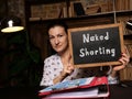 Young woman holding a black card in hands. Conceptual photo about Naked Shorting with written text