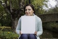 Young woman holding a blank canvas