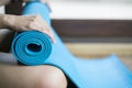 Young woman holding a blue yoga mat