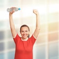 Young woman holding bottle in hand over her head. Hands up Royalty Free Stock Photo