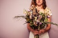 Young woman holding bouquet of dead flowers