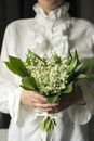 Young woman holding a bouquet of lilies of the valley Royalty Free Stock Photo