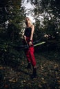 Young woman holding bow and arrow in a forest Royalty Free Stock Photo