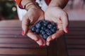young woman holding a bowl of blueberries. preparing a healthy recipe of diverse fruits, watermelon, orange and blackberries. Royalty Free Stock Photo