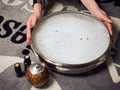 Young woman holding a bowl filled with a bath of essential oils, sprinkled with lavender flowers, next to it there are three