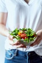 Young woman holding a bowl of healthy arugula and cherry tomato salad Royalty Free Stock Photo