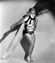 Young woman holding a broom and an illuminated Jack O' Lantern