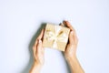 Close up of female hands holding birthday gift in vintage craft paper wrapping. Femenine composition with present in woman`s arms Royalty Free Stock Photo