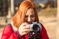 Young woman holding camera in hand. photographer woman with camera looking photos on camera. Royalty Free Stock Photo