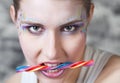 Young woman holding candy in her teeth Royalty Free Stock Photo