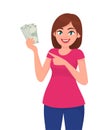 Young woman holding cash/money/currency notes in hand and pointing towards. Bank and finance concept illustration in vector. Royalty Free Stock Photo