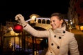 Young woman holding Christmas Ball near Rialto Bridge in Venice Royalty Free Stock Photo