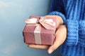 Young woman holding Christmas gift on background, closeup Royalty Free Stock Photo