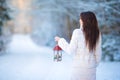 Young woman holding Christmas lantern outdoors on beautiful winter snow day Royalty Free Stock Photo