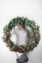 Young woman holding christmas large wreath in hands in light, seasonal holidays, rustic theme, adorning